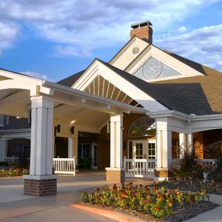 A beautiful residential building with a grand entrance and landscaped surroundings.