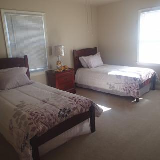 A cozy bedroom with two twin beds and a nightstand between them.