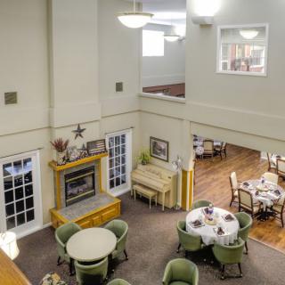 A spacious and cozy interior featuring a lounge and dining area with elegant furniture and a fireplace.