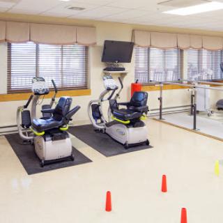 A rehabilitation gym featuring exercise bikes and a spacious area for physical therapy activities.