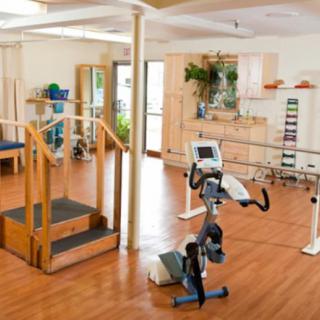 A rehabilitation room equipped with exercise machines and therapy tools.