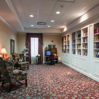 A cozy library with bookshelves, comfortable seating, and soft lighting.