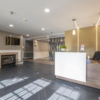 A modern lobby with a sleek reception desk and contemporary lighting.