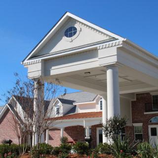 A large residential building with a prominent entrance and columns.
