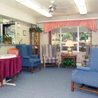 A cozy living room with armchairs and a small table under soft lighting.
