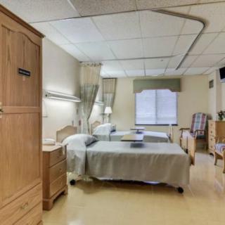 A hospital room with two beds and medical equipment.