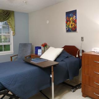 A well-organized hospital room with a bed, bedside table, and comfortable furnishings.