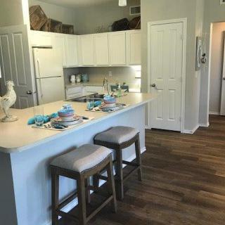 A modern kitchen with a countertop dining area and white cabinets.