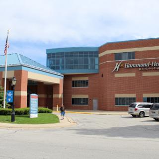 A view of a modern hospital building with clear signage and landscaped surroundings.