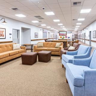 A spacious and well-lit lobby featuring comfortable seating with sofas and chairs.