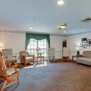 A cozy living room with rocking chairs, a sofa, and decorative elements.