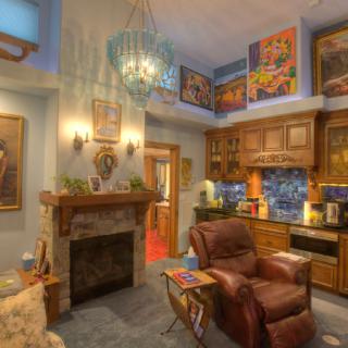 A cozy living room featuring a fireplace, comfortable seating, and vibrant artwork.