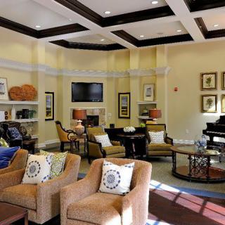 A modern and cozy living room featuring comfortable seating, a piano, and stylish decor.