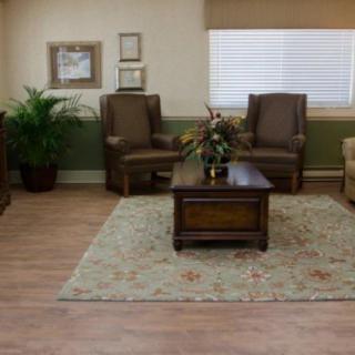 A cozy living room with comfortable chairs, a coffee table, and decorative elements.