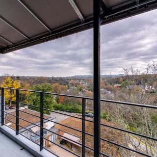 A scenic view from a balcony overlooking a lush landscape with a cloudy sky.