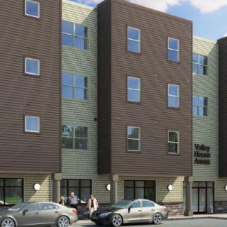 A modern apartment building with people and cars outside.