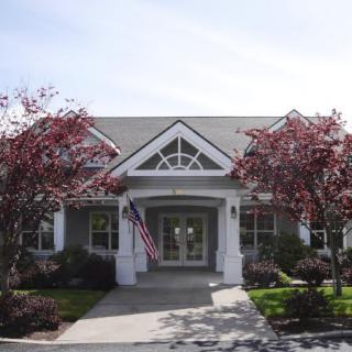 A charming house with an American flag at the entrance, surrounded by trees.