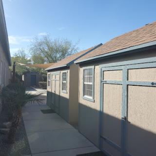 A view of a narrow pathway lined with buildings under a clear blue sky.
