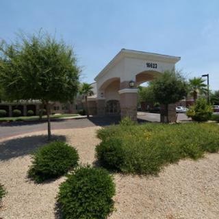 A view of a welcoming entrance to a residential complex, surrounded by well-maintained landscaping.