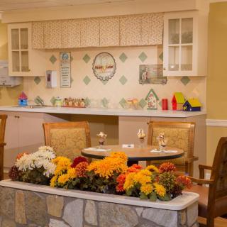 A cozy indoor kitchen and dining area adorned with vibrant flowers and charming decor.