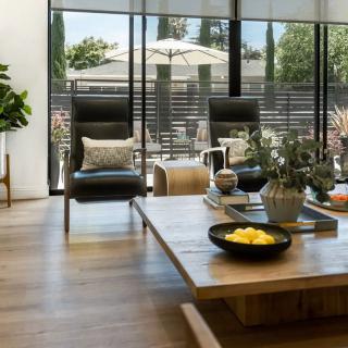 A modern living room with stylish furniture, abundant natural light, and a view of the outdoor patio.