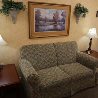 A cozy living room setup featuring a patterned sofa, decorative wall art, and warm lighting.