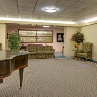 A spacious lobby with a grand piano, seating area, and elegant decor.