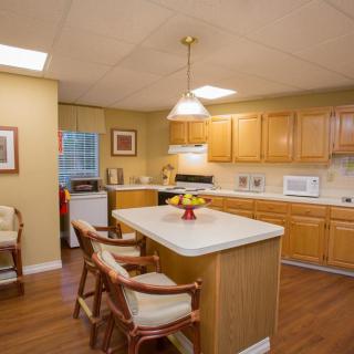 A cozy kitchen with wooden cabinets, an island, and bar stools.