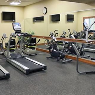 A small gym with various exercise equipment including treadmills and stationary bikes.