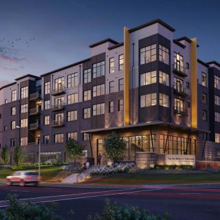 Modern apartment building in an urban setting during the evening.