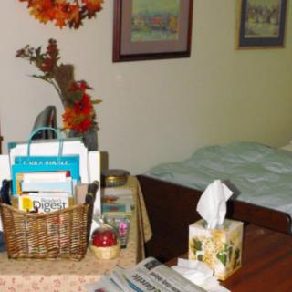 A cozy bedroom scene with a decorated table, featuring a basket of items and a tissue box.
