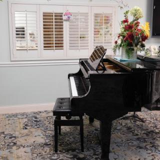 A beautifully arranged grand piano with a charming floral arrangement, adding elegance to the living space.