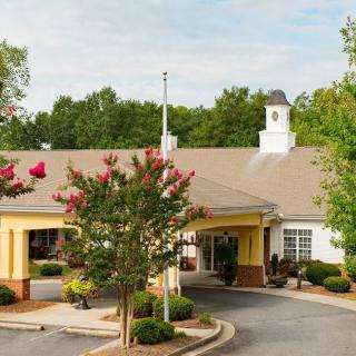 A picturesque building entrance surrounded by trees and landscaping.
