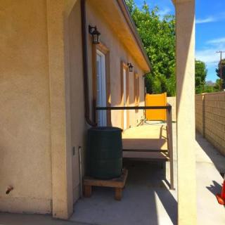 A sunny view of a house's side entrance with a small deck and railing.