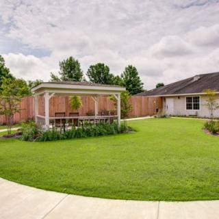 A neatly landscaped backyard featuring a gazebo and well-maintained lawn.