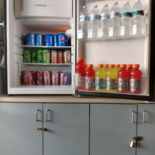 A well-stocked fridge featuring a variety of beverages including sodas, sports drinks, and bottled water.