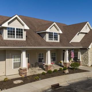 A suburban residential home with a traditional design and landscaped front yard.
