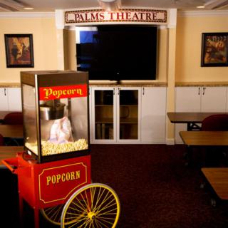 A cozy home theater setup featuring a popcorn machine and comfortable seating.