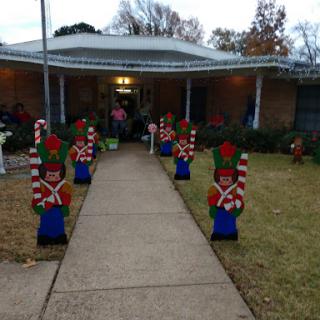 A festive front yard adorned with cheerful toy soldier decorations, leading up to a welcoming entrance.