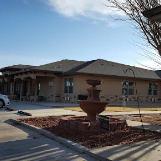 A modern residential building with a decorative fountain in the front yard.