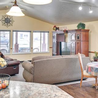 A cozy living area featuring a comfortable sofa and a dining space, illuminated by natural light.