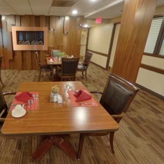 A cozy dining area with neatly set tables and wooden interior decor.