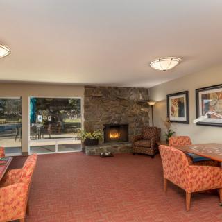 A cozy living room with a fireplace, comfortable seating, and decorative artwork.