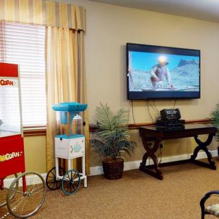 A cozy living room setup with a TV, popcorn machine, and cotton candy machine.