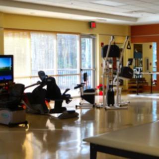 A bright fitness center with various exercise machines and equipment.