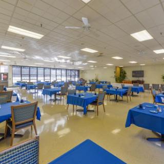 A spacious dining area featuring blue tablecloths and ample seating.