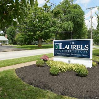The entrance sign of The Laurels, a healthcare facility, surrounded by well-maintained landscaping.