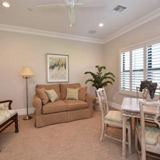 A cozy living room with a sofa, dining set, and decorative elements.