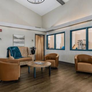 A cozy waiting room with comfortable seating and a wooden floor.