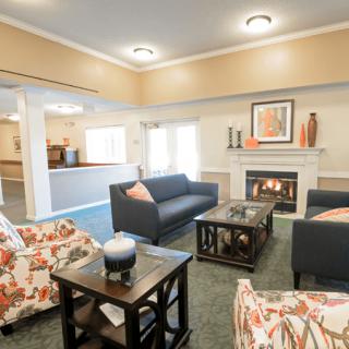 A cozy living room with modern furniture and a fireplace.